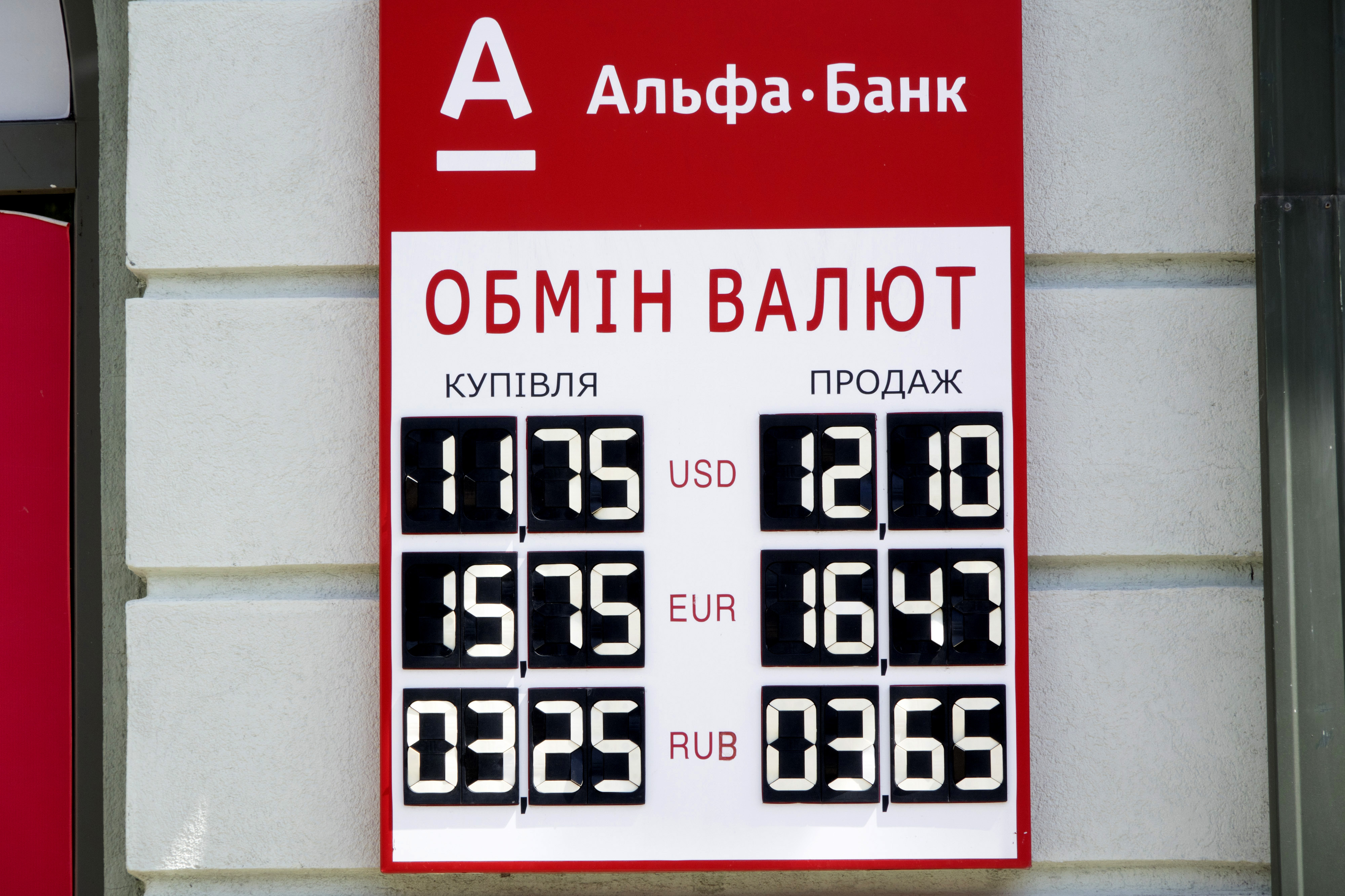A foreign currency exchange rate sign sits on display outside an Alfa Bank bank branch in Kiev, Ukraine, on Thursday, May 29, 2014. Russia's central bank ordered the Ukrainian units of nine banks to cease operations in Crimea, saying they have failed to meet their obligations to depositors and clients. Photographer: Vincent Mundy/Bloomberg