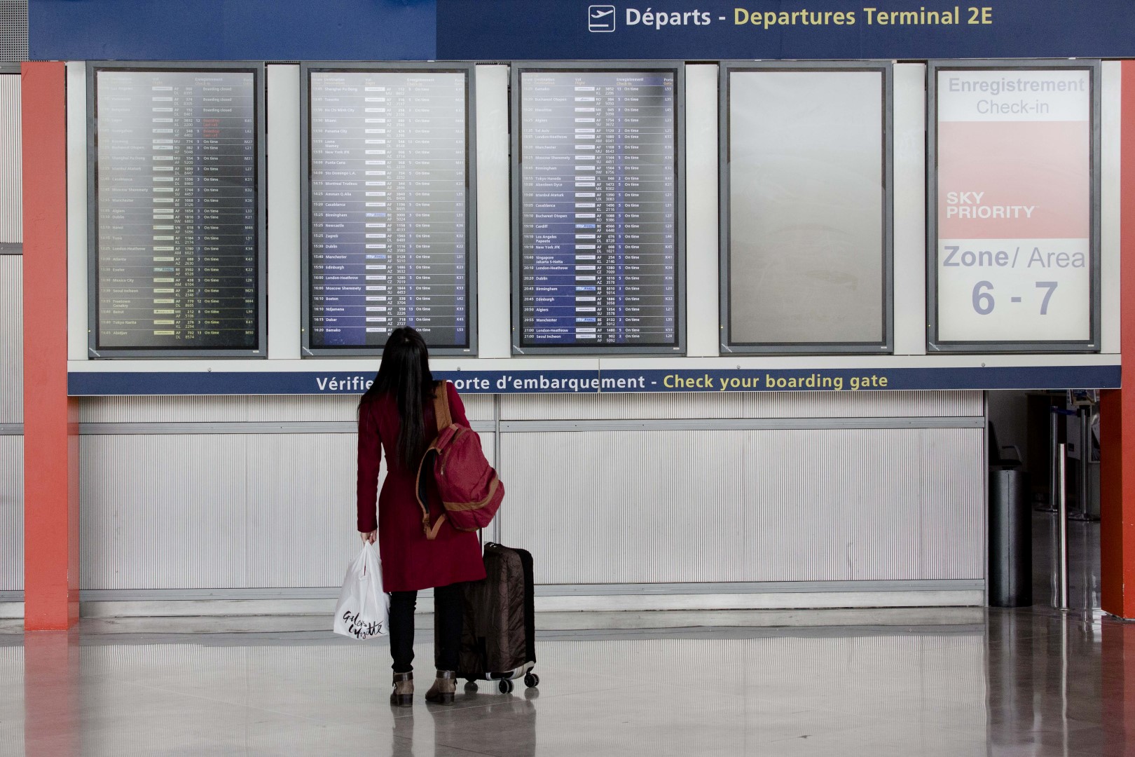 A passenger looks at flight departure information screens at Charles de Gaulle airport, operated by Aeroports de Paris, in Paris, France, on Thursday, Jan. 28, 2016. Air France-KLM Group Chief Executive Officer Alexandre De Juniac is negotiating with unions representing cabin and ground crews at the Air France brand and Dutch division KLM, as well as pilots at the French unit, after pulling a plan to expand its Transavia low-cost arm across Europe. Photographer: Marlene Awaad/Bloomberg
