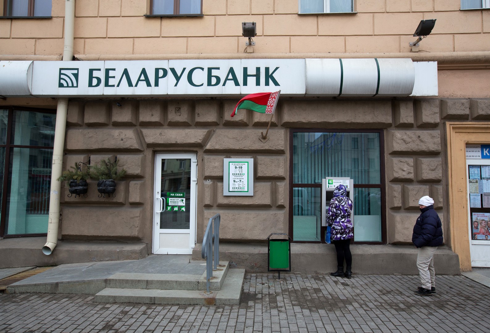 A customer waits to use an automated teller machine (ATM) outside a Belarusbank bank branch in Minsk, Belarus, on Wednesday, March 16, 2016. European Union governments scrapped sanctions on leaders of Belarus in an effort to pry the former Soviet republic out of the shadow of the Kremlin. Photographer: Andrey Rudakov/Bloomberg