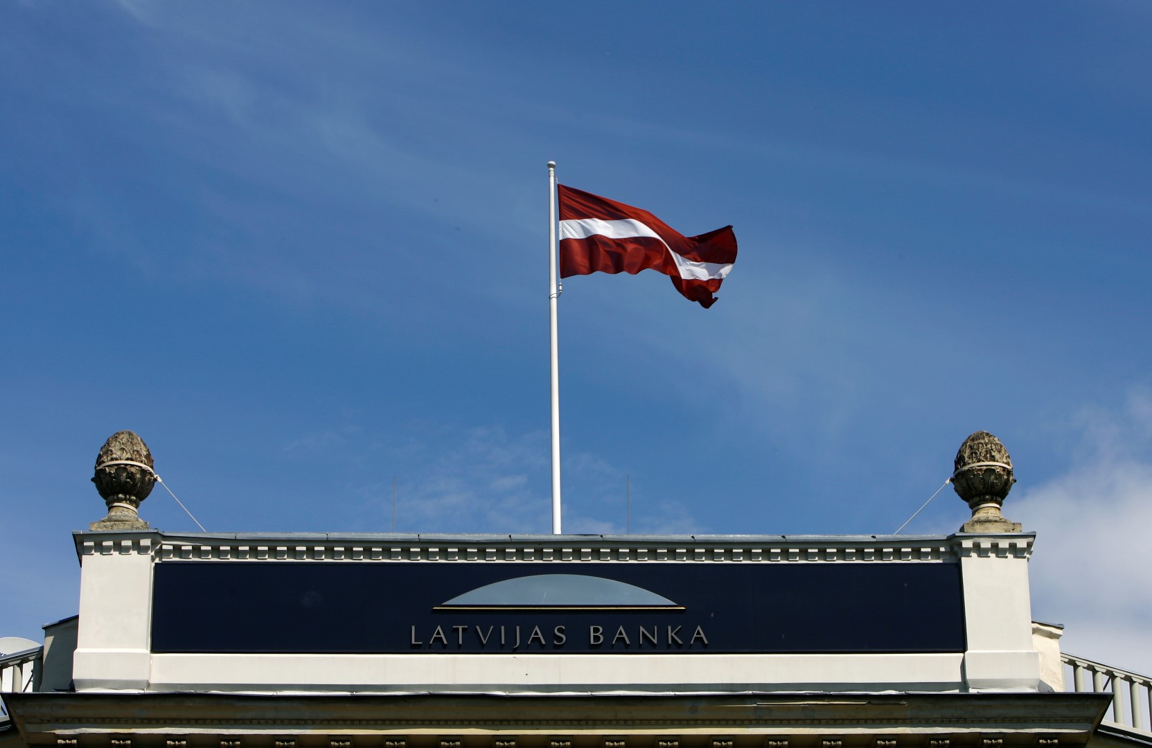 Latvia's flag waves over the Central Bank's main office building in Riga May 13, 2009. Latvia's central bank said on Wednesday it had revised its economic growth forecast to -16.5 percent from the previous forecast of -12.0 percent, and it had cut its refinancing rate to 4 percent from 5 percent. REUTERS/Ints Kalnins (LATVIA SOCIETY POLITICS BUSINESS) - GM1E55D1MDH01