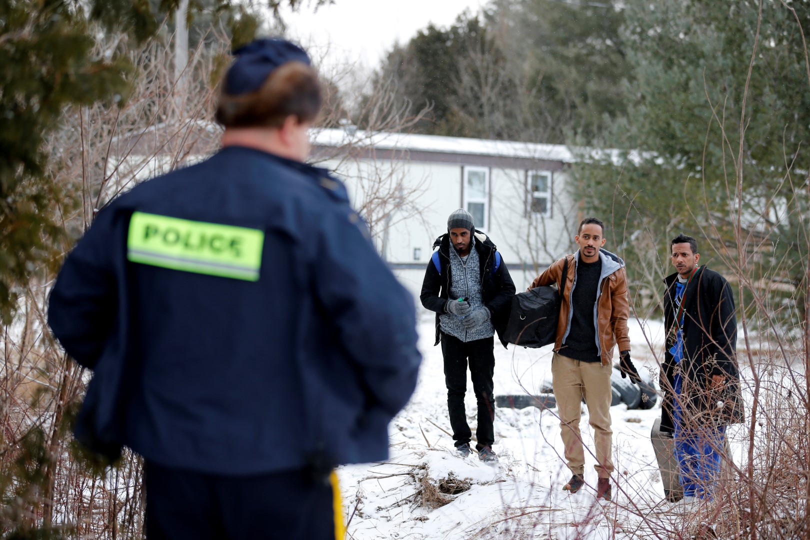 Three men who claimed to be from Sudan and were driven by taxi driver Curtis Seymour, are confronted by Royal Canadian Mounted Police (RCMP) as they prepare to cross illegally the U.S.-Canada border into Hemmingford, Quebec, Canada, March 4, 2017. The men were taken into custody after walking across the U.S.-Canada border. REUTERS/Christinne Muschi           SEARCH "MUSCHI CABBIE" FOR THIS STORY. SEARCH "WIDER IMAGE" FOR ALL STORIES. - RC19055660A0