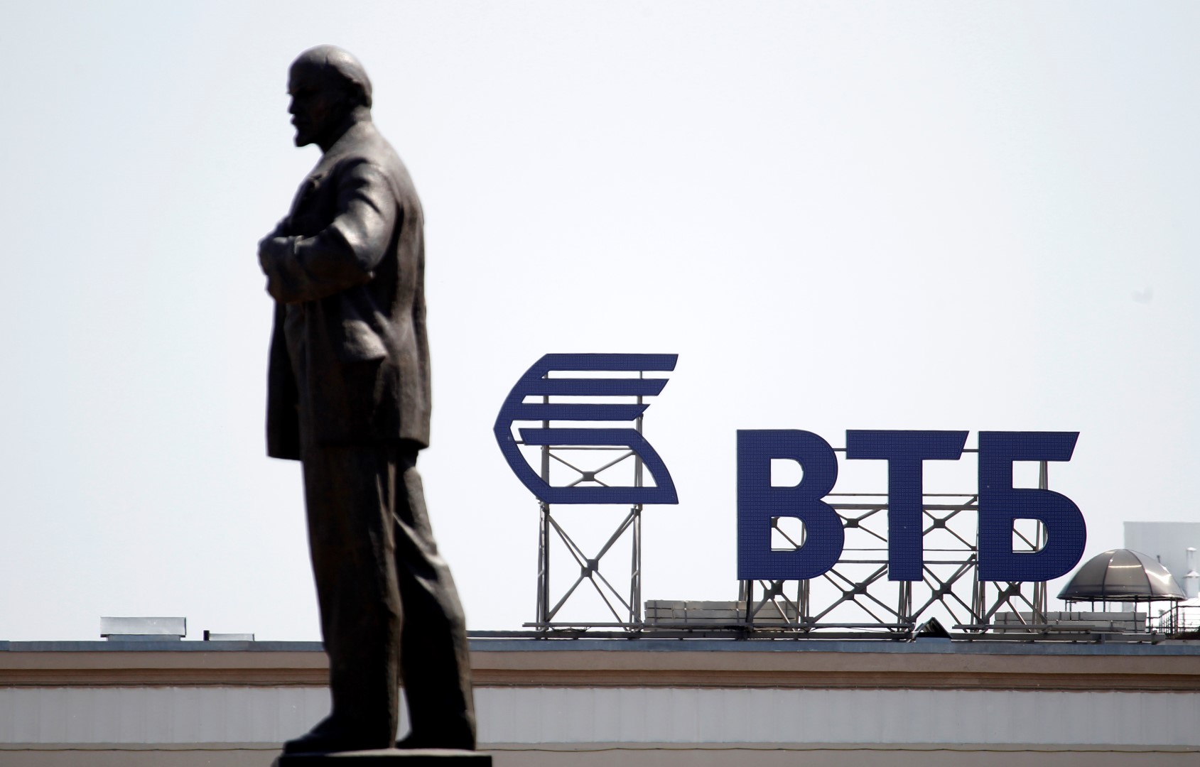 A sign for the logo of VTB Bank on the top of a building is pictured past a monument of Soviet state founder Vladimir Lenin in central Stavropol, southern Russia July 17, 2014. REUTERS/Eduard Korniyenko (RUSSIA - Tags: BUSINESS POLITICS LOGO CITYSCAPE) - GM1EA7H1O5F01