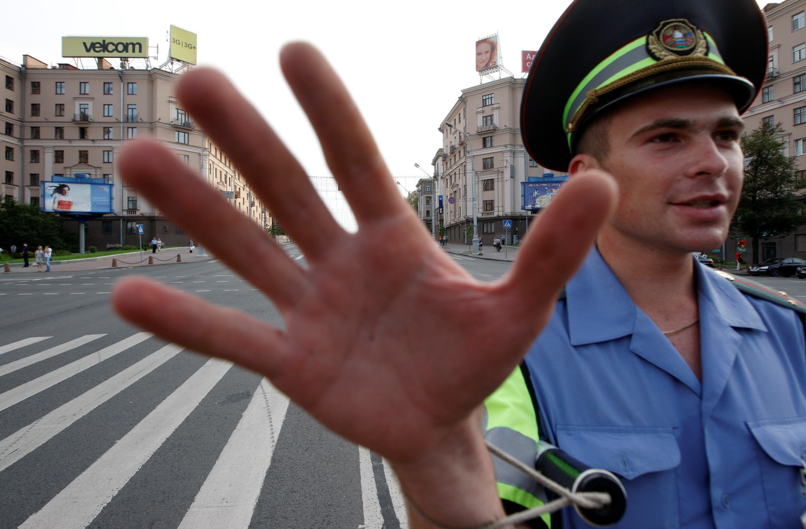 A traffic policeman tries to stop a photographer from taking pictures at an empty Independence avenue in central Minsk, July 21, 2011. The main street in Belarussian capital was blocked to prevent a protest rally against a rise in gasoline prices, which happened on Thursday.  REUTERS/Vasily Fedosenko(BELARUS - Tags: CIVIL UNREST ENERGY) - GM1E77M089T01