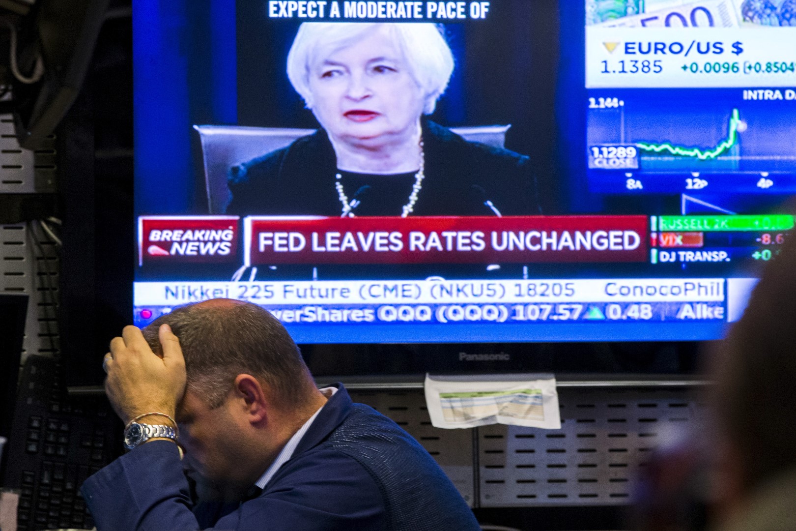A trader works underneath a television screen showing Federal Reserve Chair Janet Yellen announcing that the Federal Reserve will leave interest rates unchanged on the floor of the New York Stock Exchange in New York September 17, 2015. REUTERS/Lucas Jackson - RTS1MCU