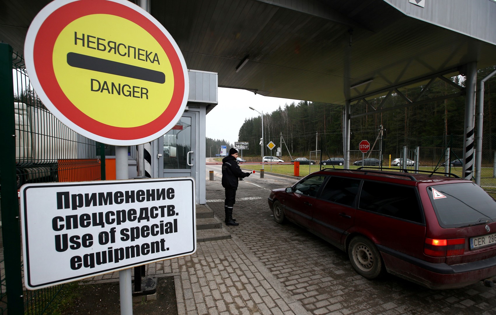 A Belarussian border guard stops a car at a checkpoint Kotlovka at the border between Belarus and Lithuania, near the village of Kotlovka, Belarus, November 22, 2016. Photo taken November 22, 2016. REUTERS/Vasily Fedosenko - S1AEUOLIVJAB
