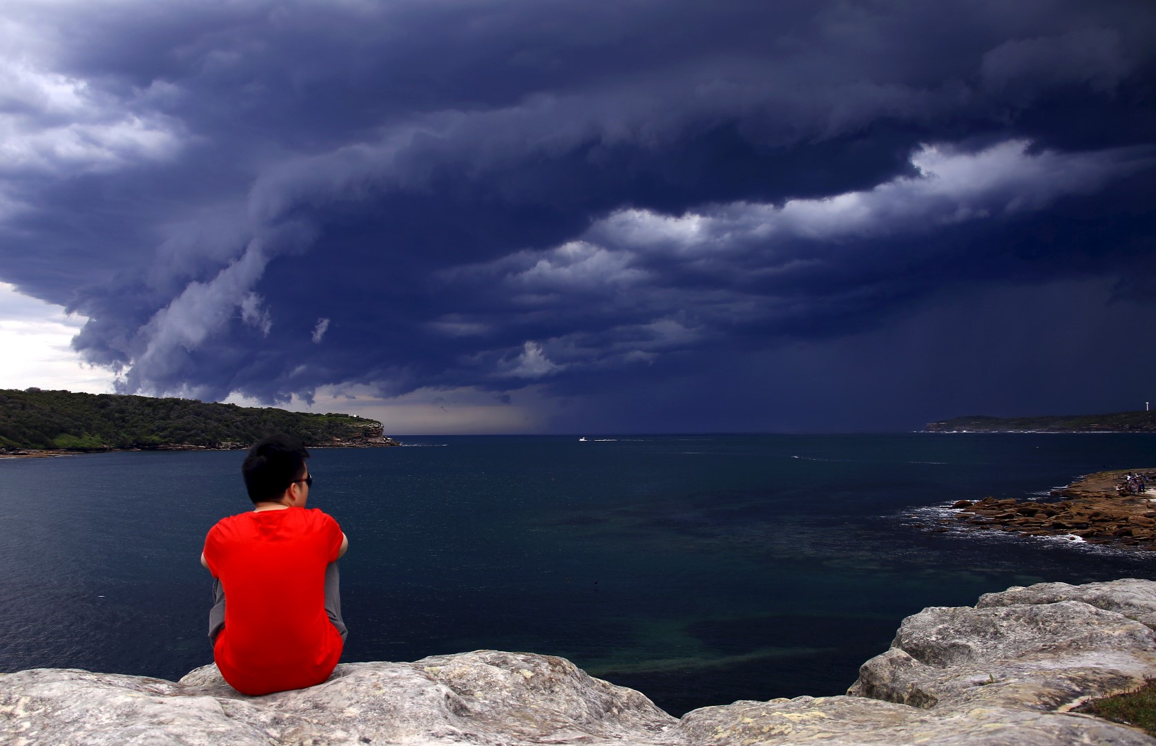 A Chinese tourist watches storm clouds moving along the coast towards the city of Sydney, Australia, November 6, 2015. Powerful storms swept across the city on Friday, with the Australian Bureau of Meteorology issuing a warning for severe thunderstorms with large hailstones, heavy rainfall and damaging winds, local media reported. REUTERS/David Gray - GF20000047792